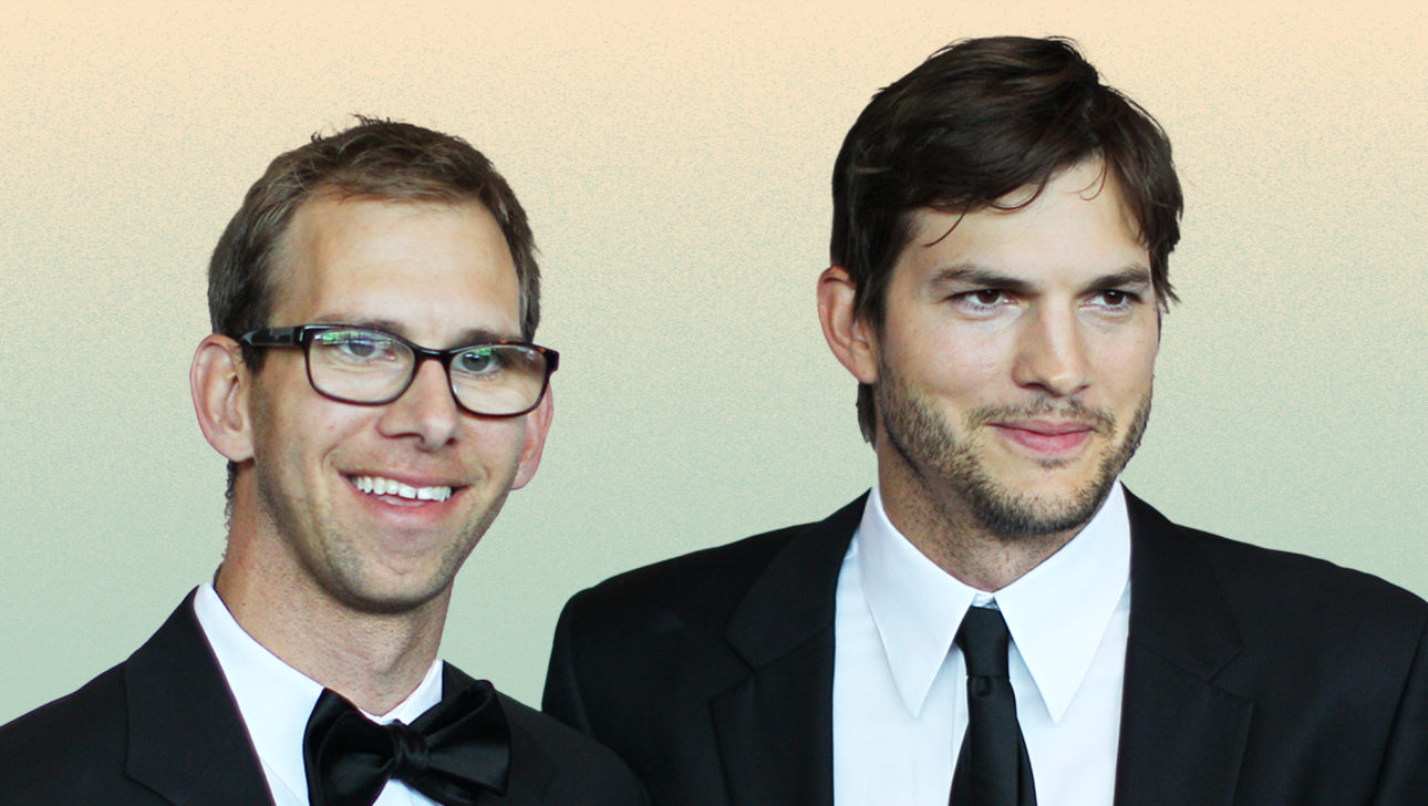Ashton Kutcher's twin brother Michael. Staniding together in black suits, smiling.