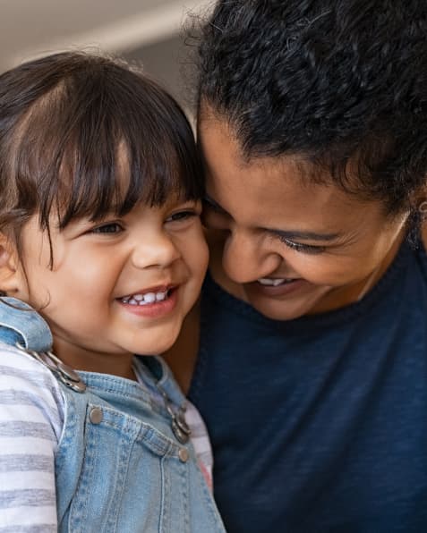 A young girl and woman smiling.