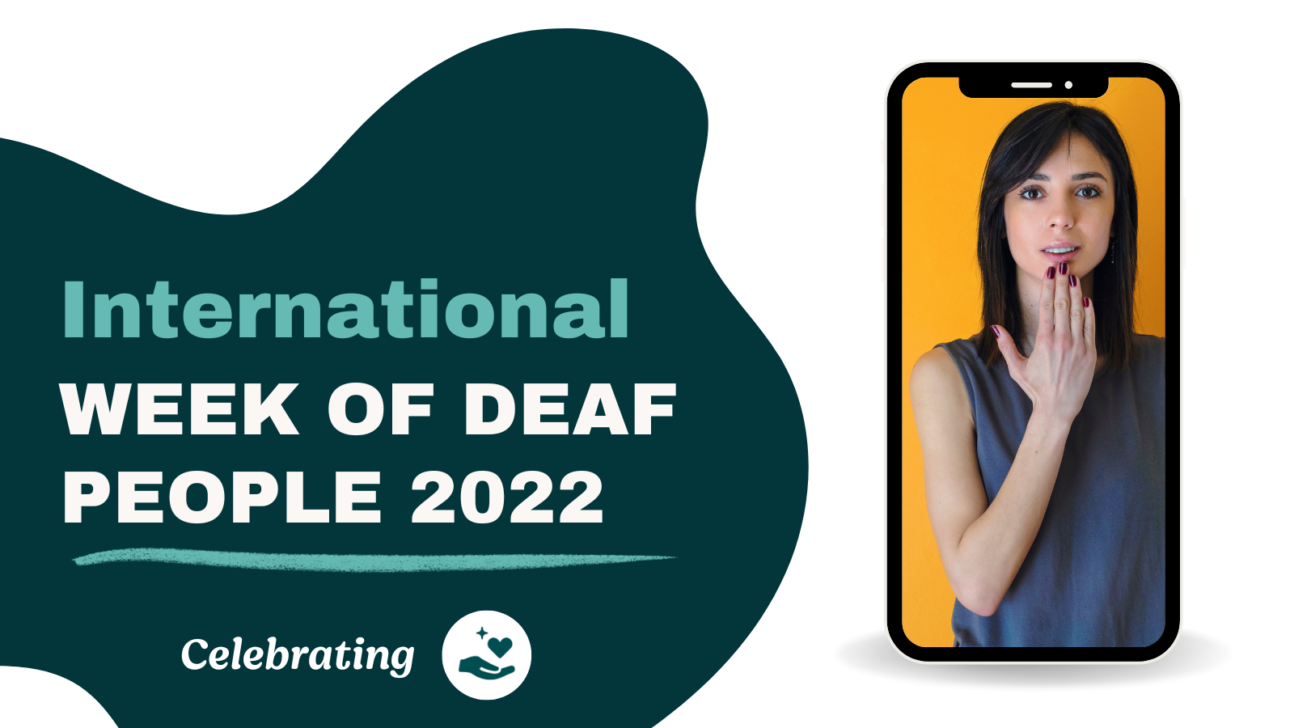 Image of a teal abstract shape with text reading "International Week of Deaf People" next to a blue hand holding a heart and cell phone showing a young women with black hair communicating in sign language.