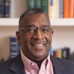 Portrait of Paul Davis, a black man in a collared shirt and glasses.