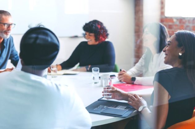 A group of people having a meeting around a table.