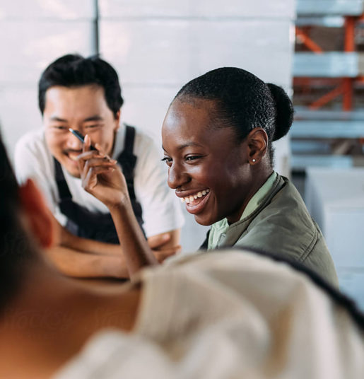 A woman laughs with her coworkers around a table