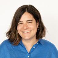 Portrait of a smiling woman with shoulder length hair and a blue button-up shirt